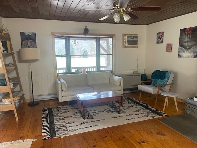 living room featuring baseboard heating, a wall mounted AC, wood ceiling, and hardwood / wood-style flooring