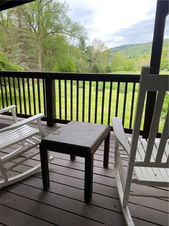 wooden terrace featuring a lawn