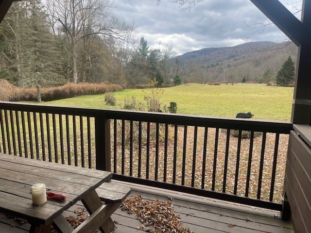 wooden terrace with a mountain view and a lawn