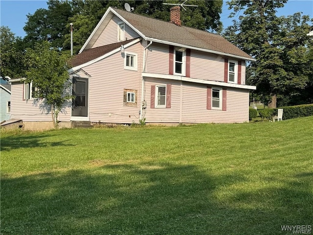 rear view of house featuring a yard