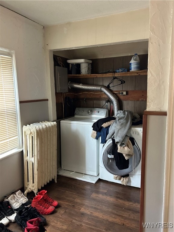 washroom featuring washer / dryer, dark hardwood / wood-style flooring, electric panel, and radiator