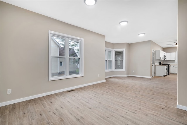 unfurnished living room with ceiling fan and light hardwood / wood-style flooring