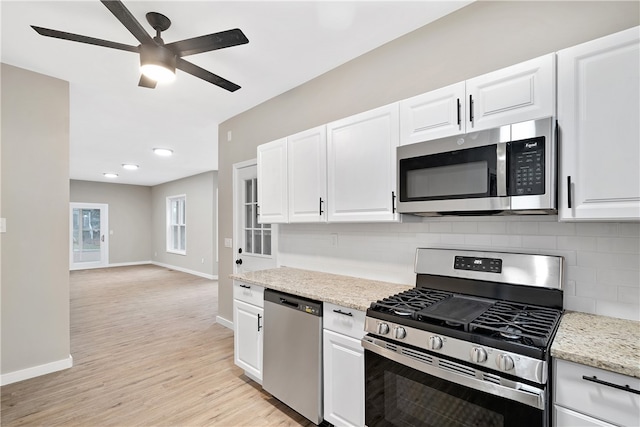 kitchen featuring decorative backsplash, white cabinetry, light hardwood / wood-style floors, and appliances with stainless steel finishes