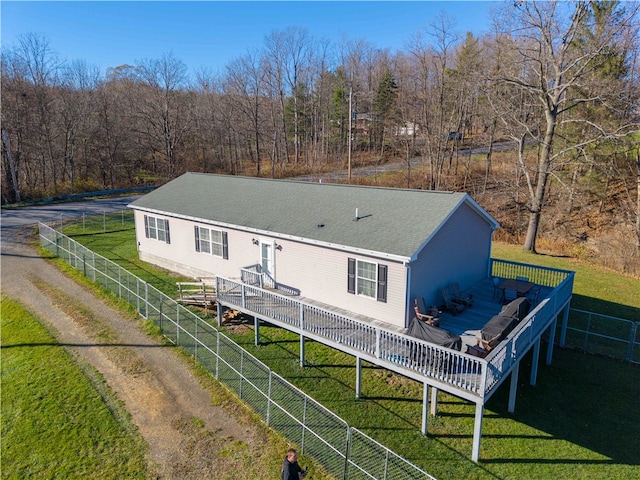 back of house featuring a deck and a lawn