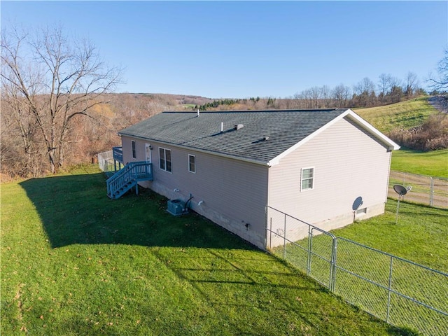 view of property exterior with a shingled roof, a lawn, crawl space, central AC, and fence