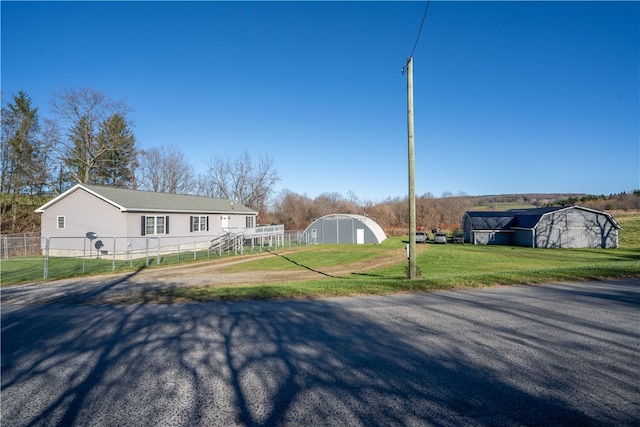 view of front of home featuring a front yard and an outdoor structure