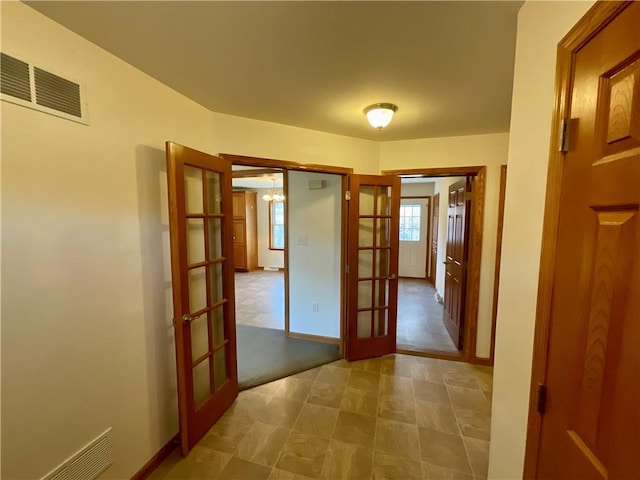 corridor featuring french doors, visible vents, and baseboards