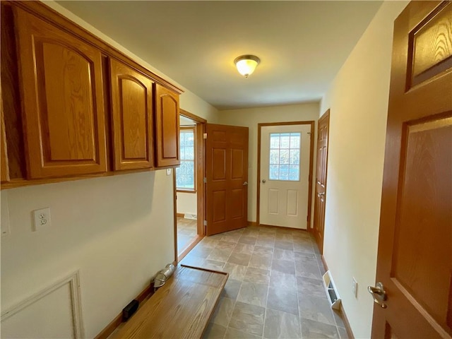 doorway to outside featuring plenty of natural light, visible vents, and baseboards