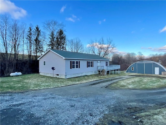 view of front facade featuring driveway, a detached garage, an outbuilding, and an outdoor structure