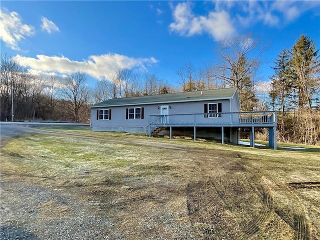 view of front of property with a front yard and a wooden deck