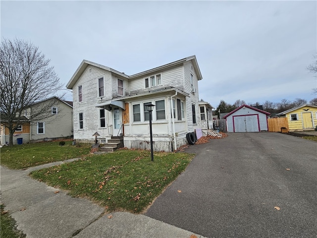 view of front property with a garage, an outdoor structure, and a front yard