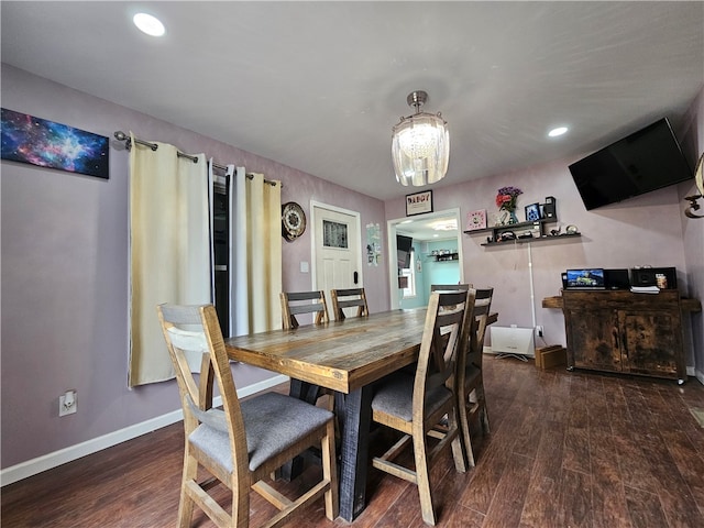 dining space with dark hardwood / wood-style floors and an inviting chandelier