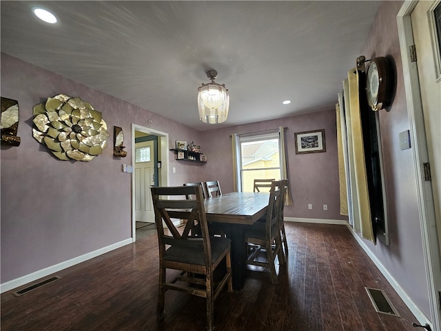 dining space featuring an inviting chandelier and dark wood-type flooring