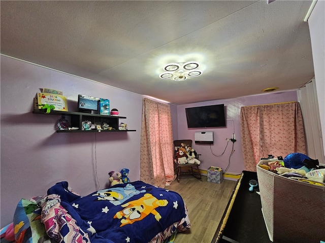 bedroom with hardwood / wood-style floors and a textured ceiling