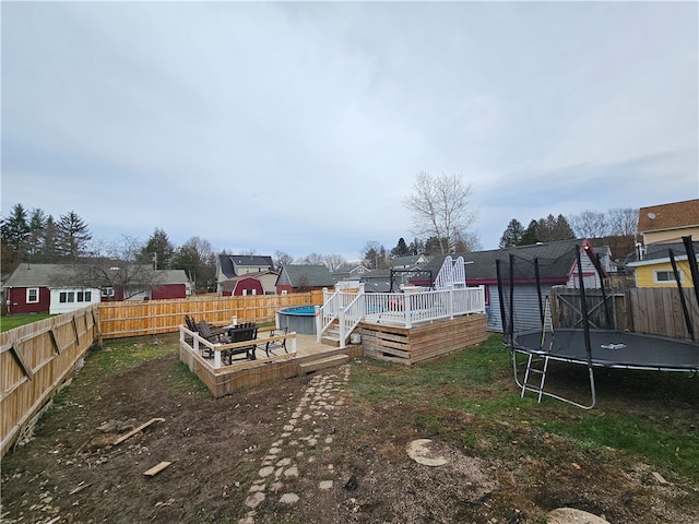 view of yard featuring a swimming pool side deck and a trampoline