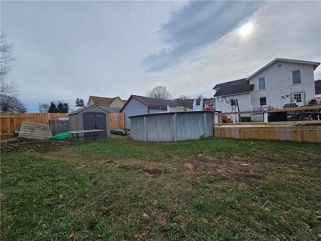 view of yard featuring a swimming pool side deck and a storage unit