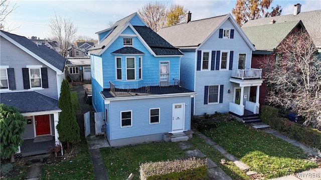 view of front of home featuring a front yard and a balcony