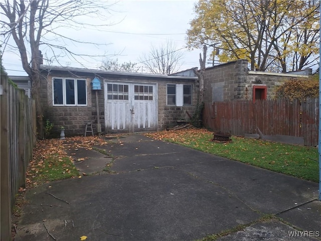 exterior space featuring an outbuilding, driveway, an attached garage, and fence