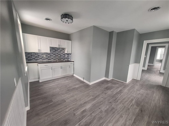 kitchen featuring dark countertops, visible vents, and white cabinets