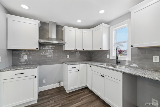 kitchen featuring white cabinets, dark wood-type flooring, and wall chimney range hood