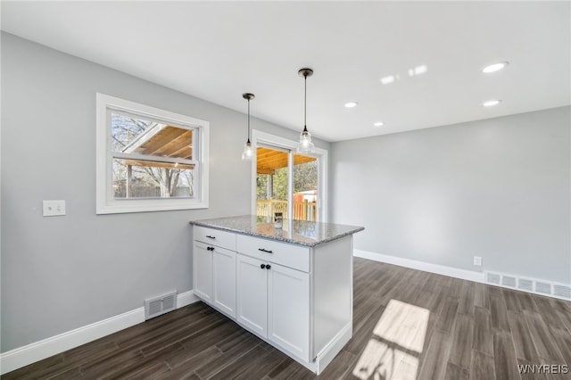 kitchen featuring white cabinets, plenty of natural light, dark hardwood / wood-style flooring, and light stone counters