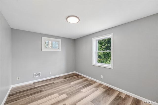 unfurnished room featuring plenty of natural light and light wood-type flooring