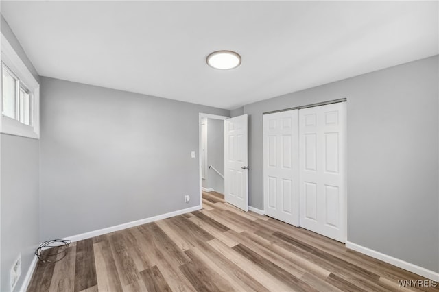 unfurnished bedroom with a closet and light hardwood / wood-style floors