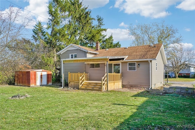 rear view of property featuring a lawn and a storage unit