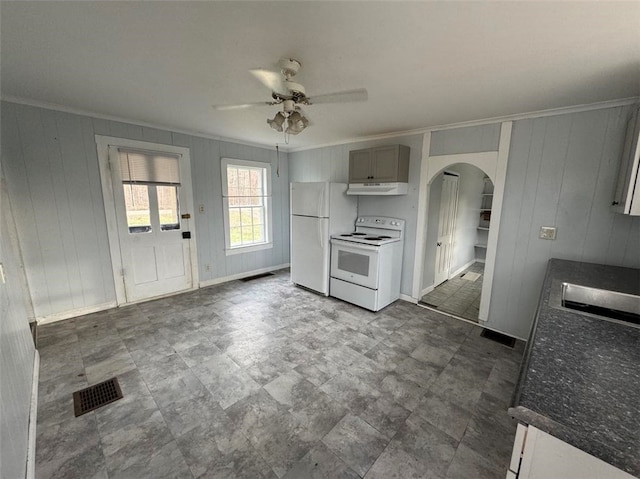 kitchen featuring gray cabinetry, ceiling fan, crown molding, wood walls, and white appliances