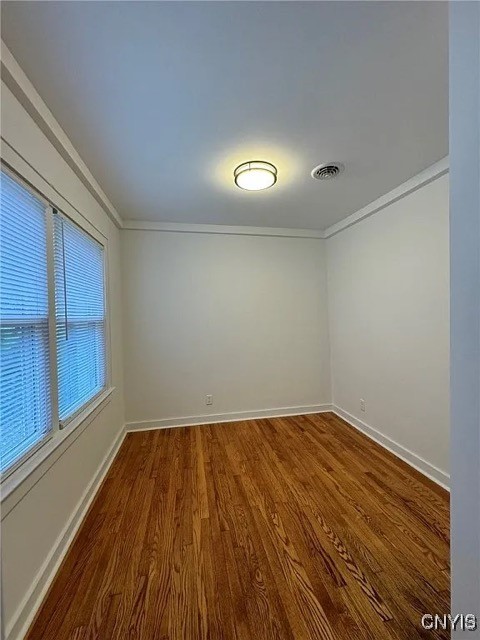 spare room with hardwood / wood-style floors and ornamental molding