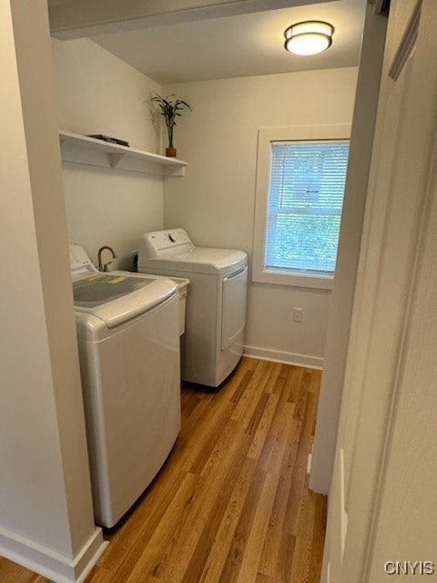 clothes washing area featuring independent washer and dryer and light wood-type flooring