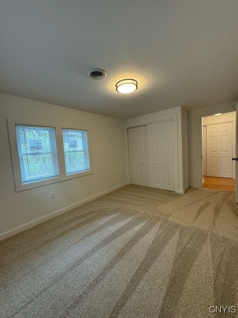 unfurnished bedroom featuring carpet flooring and a closet