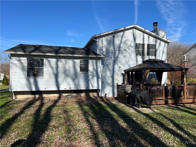 back of property featuring a gazebo, a deck, and a lawn