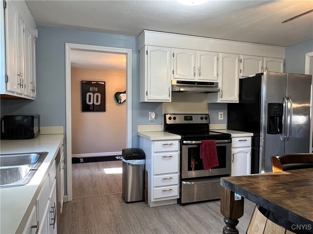 kitchen with sink, white cabinetry, stainless steel appliances, and light wood-type flooring