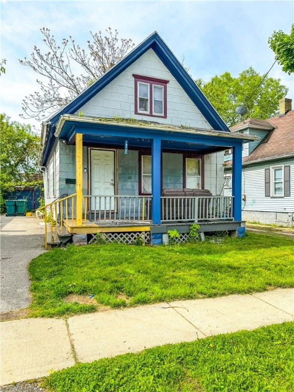 bungalow featuring a porch and a front lawn