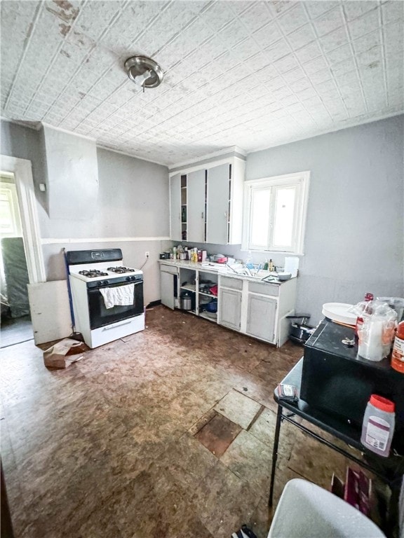 kitchen with white cabinets and white gas stove