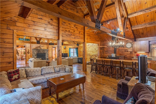 living room with wood walls, light hardwood / wood-style floors, wood ceiling, and high vaulted ceiling