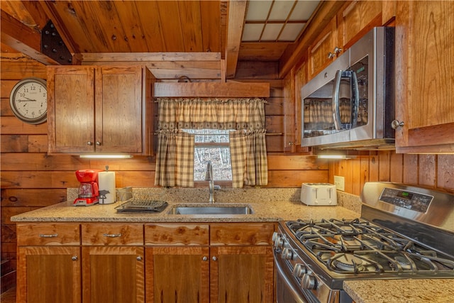 kitchen featuring wooden walls, wooden ceiling, sink, and appliances with stainless steel finishes