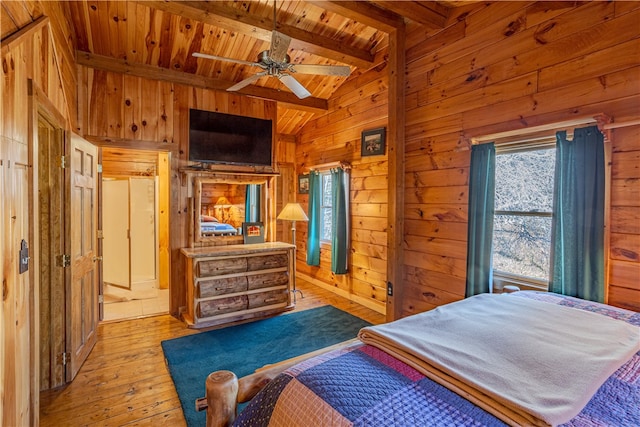 bedroom featuring light wood-type flooring, wood ceiling, ceiling fan, wooden walls, and vaulted ceiling with beams