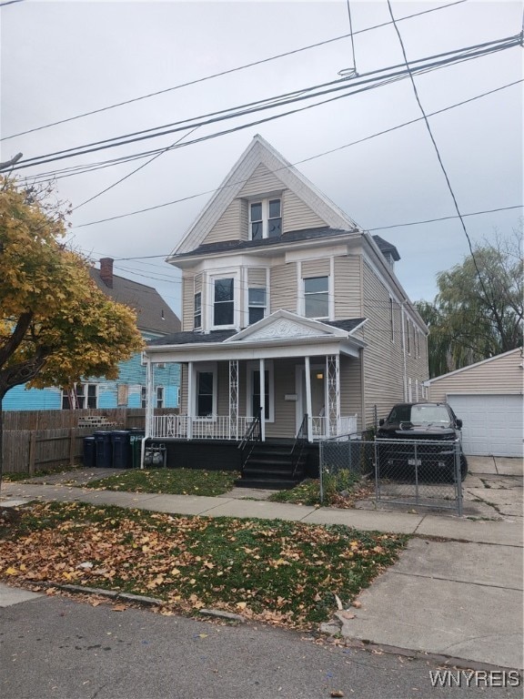 view of front facade featuring an outdoor structure, a porch, and a garage