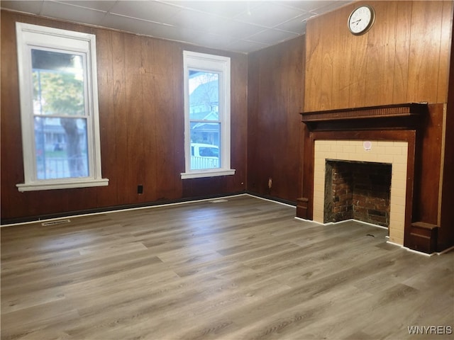 unfurnished living room with wood-type flooring and wood walls