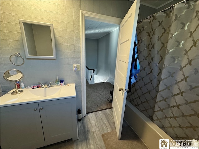 bathroom with wood-type flooring, vanity, and shower / bath combination with curtain