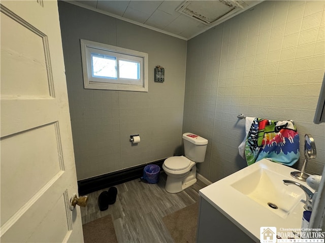 bathroom with hardwood / wood-style floors, vanity, toilet, and ornamental molding