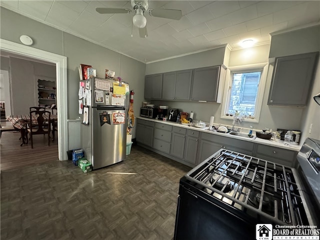 kitchen with gray cabinetry, ceiling fan, sink, and stainless steel appliances