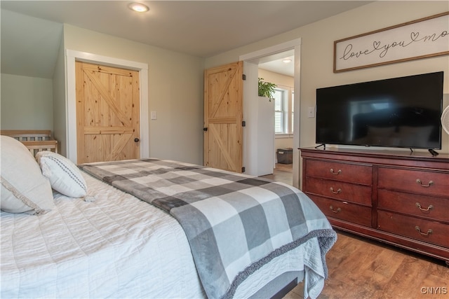 bedroom with connected bathroom and light wood-type flooring