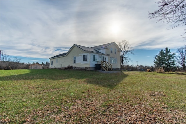 view of side of home with a yard