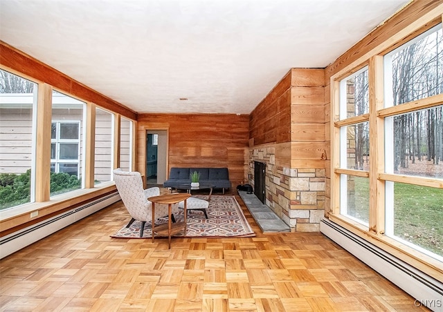 sunroom / solarium with a fireplace and a baseboard heating unit