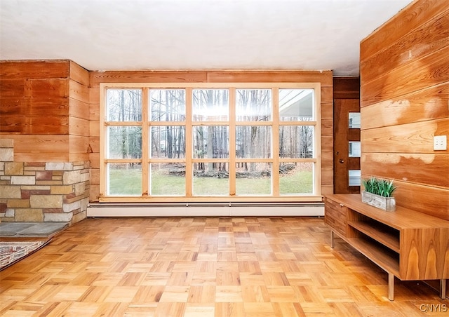 interior space with light parquet flooring, a wealth of natural light, and wood walls