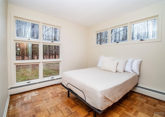 bedroom featuring multiple windows, parquet floors, and a baseboard radiator