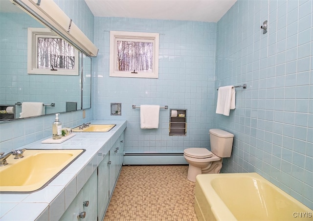 bathroom featuring baseboard heating, vanity, tile walls, and toilet